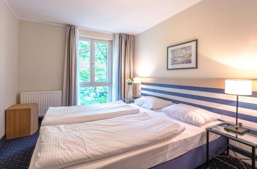 een hotelkamer met 2 bedden en een raam bij Strandhafer an der Seebrücke in Zingst
