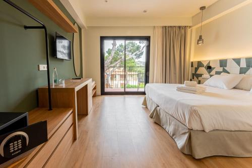 a hotel room with a large bed and a window at Hotel Santanyi Port in Cala Figuera