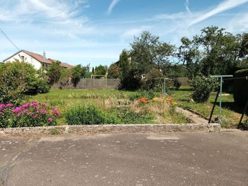 a garden with flowers on the side of a road at Maison familiale au coeur des Vosges in Aumontzey
