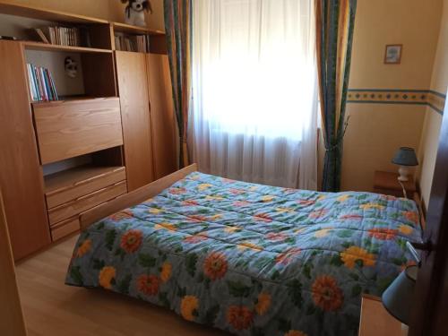a bedroom with a bed with a colorful comforter at Maison familiale au coeur des Vosges in Aumontzey