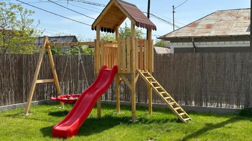 a playground with a red slide and a ladder at Bobocel Villa in Sfântu Gheorghe