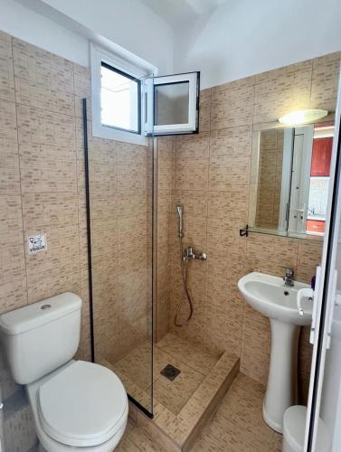 a bathroom with a shower and a toilet and a sink at Aurora House in Sarti