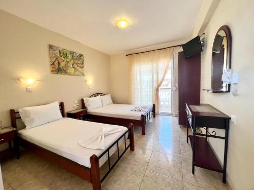 a room with two beds and a television in it at Aurora House in Sarti