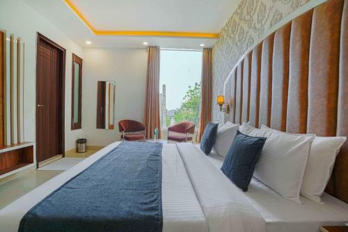 a bedroom with a large bed with a large window at Hotel Paras in Zirakpur