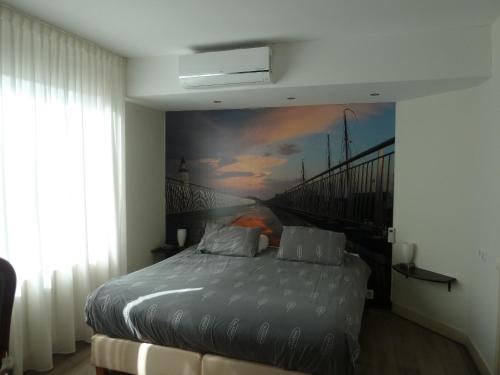 een slaapkamer met een bed met een schilderij aan de muur bij Hotel Centraal in Harlingen