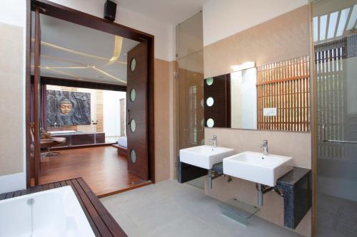 a bathroom with two sinks and a large mirror at StayVista at The Yercaud Bungalow with Pvt Pool in Yercaud