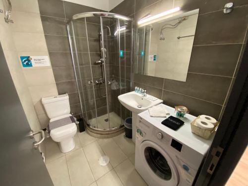 a bathroom with a toilet sink and a washing machine at Spetson Modern 56sqm apt in Piraeus in Piraeus