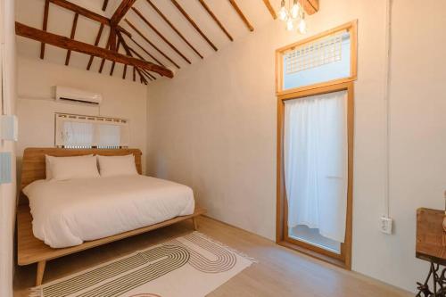 a bedroom with a white bed and a window at Spring Day in Jeonju