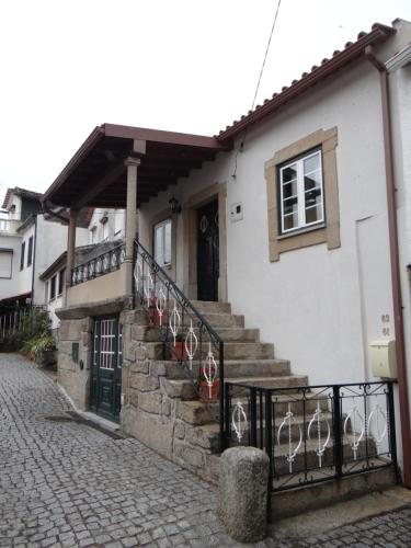 a white house with stairs and a window and a door at Casa Luizinho in Seixo da Beira