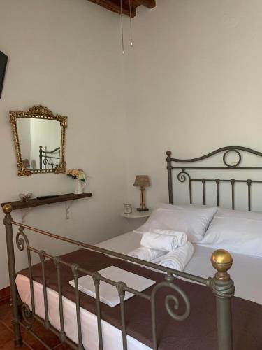 - une chambre avec un lit et un miroir mural dans l'établissement Stefanoula's house, à Kimolos