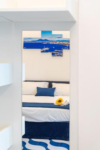 a bedroom with a bed with blue and white pillows at Blumare Home in Vico Equense