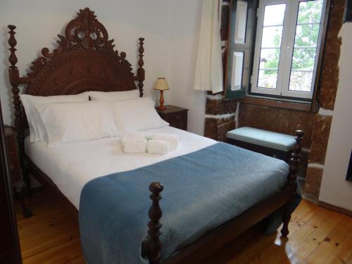 - une chambre avec un grand lit et une tête de lit en bois dans l'établissement Casa Luizinho, à Seixo da Beira