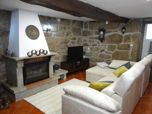 a living room with a couch and a fireplace at Casa Luizinho in Seixo da Beira