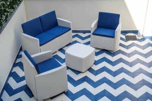 two chairs and a table on a blue and white floor at Blumare Home in Vico Equense
