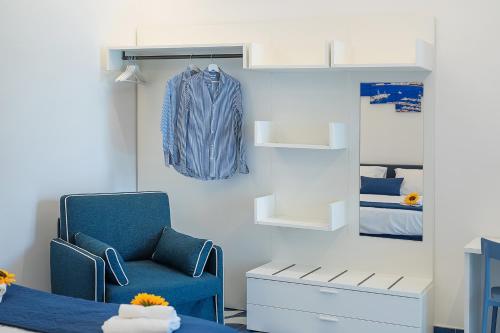 una stanza con una sedia blu e una giacca blu su un muro di Blumare Home a Vico Equense