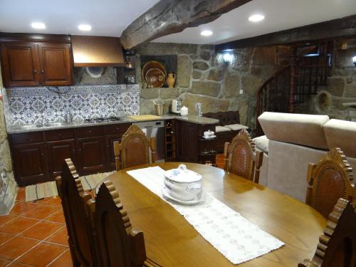 a kitchen and dining room with a wooden table at Casa Luizinho in Seixo da Beira