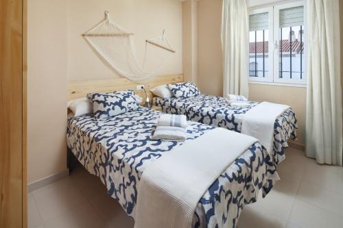 2 Betten in einem Zimmer mit blauer und weißer Bettwäsche in der Unterkunft Monte Meru in Xilxes