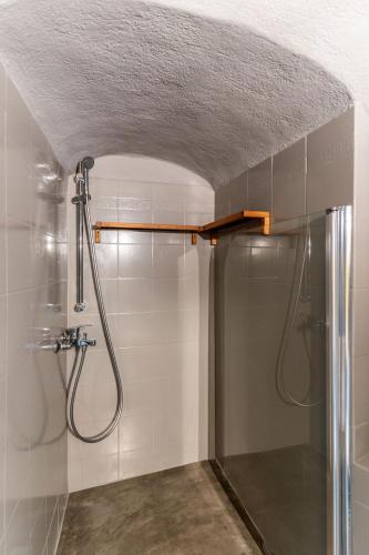 a bathroom with a shower with a glass door at Mardanza House in Imerovigli