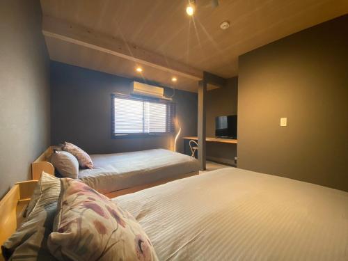 um quarto com duas camas e uma televisão em Ebisu-Sakura 恵美須～桜 em Osaka