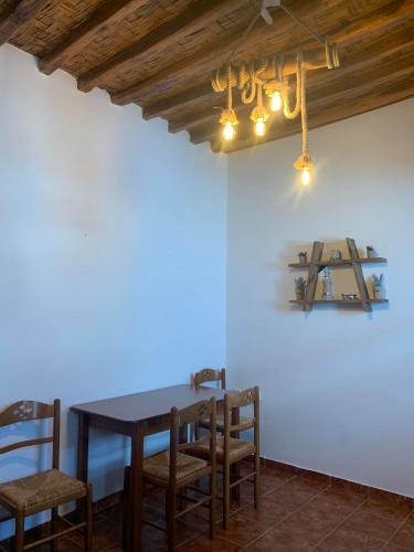 a dining room with a wooden table and chairs at Stefanoula's house in Kimolos