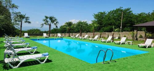 a group of chairs and a swimming pool with a bunch ofitures at Tilia Kvareli Resort in Kvareli