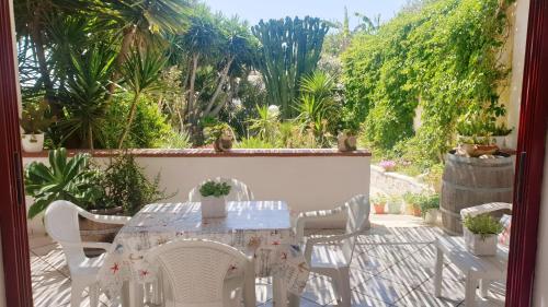 einen weißen Tisch und Stühle auf einer Terrasse mit Pflanzen in der Unterkunft La Vecchia Marina sul mare in Marinella di Selinunte