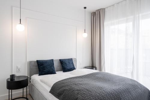 um quarto com uma cama com almofadas azuis e uma janela em RentPlanet - Atal City Square em Breslávia
