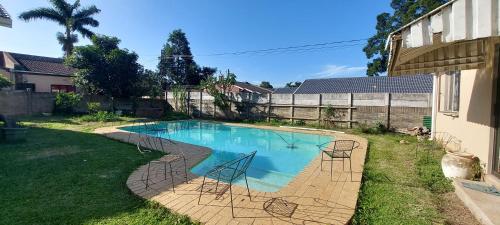 einen Pool mit Stühlen im Hof in der Unterkunft Luxury stays in Empangeni