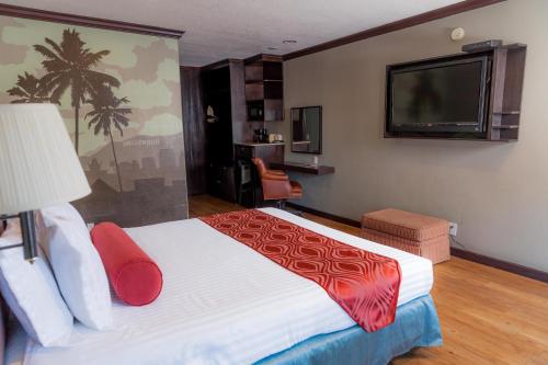 a hotel room with a bed and a flat screen tv at The Dixie Hollywood in Los Angeles