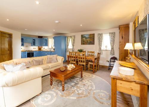 a living room with a white couch and a table at Orchardleigh Estate in Frome