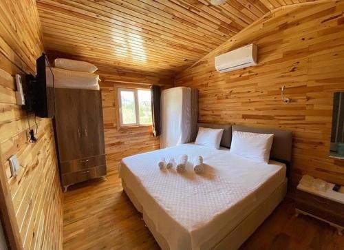 a bedroom with a bed in a wooden cabin at Adrasan Akasya Pansiyon in Kumluca