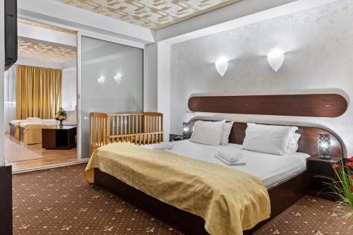a bedroom with a large bed and a room with two beds at Hotel Charter Otopeni in Otopeni