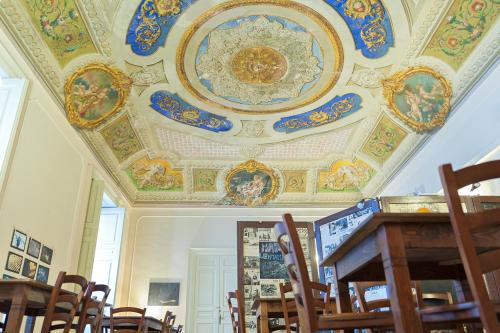 a room with a ceiling with paintings on it at Ostello degli Elefanti in Catania