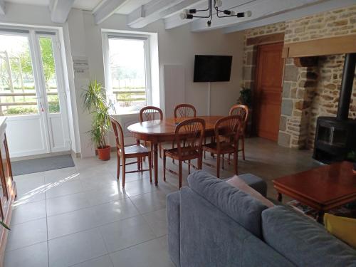 a living room with a table and chairs and a couch at Gîte du LERRE Baie du Mont St Michel Meublé de Tourisme 3 Etoiles in Bacilly