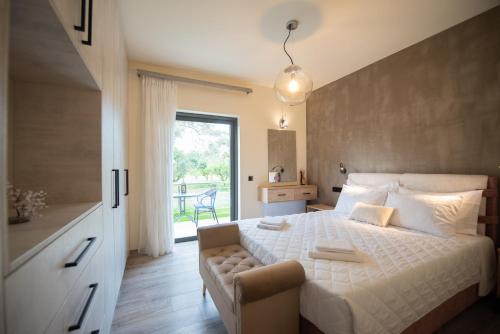 a bedroom with a white bed and a window at Aerinos private villa in Lefkada Town