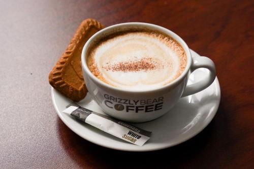 a cup of coffee on a plate with a cigarette at Hamlet Hotels Maidstone in Maidstone