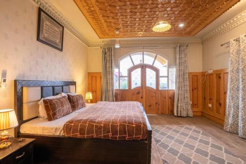 1 dormitorio con cama y ventana grande en Stay Vista at Ivy Manor, en Srinagar