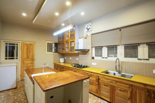 a large kitchen with wooden cabinets and a sink at Stay Vista at Ivy Manor in Srinagar