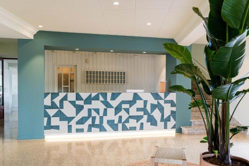 a lobby with a blue and white wall at Hotel Santanyi Port in Cala Figuera
