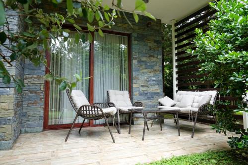 um pátio com cadeiras e uma mesa numa casa em Luxury Dreamland Oasis Apartments em Chakvi