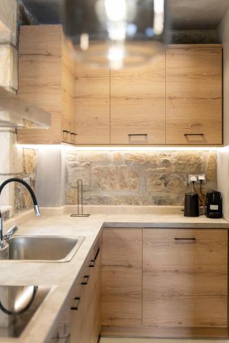 a kitchen with wooden cabinets and a sink at Nature Villas Myrthios in Plakias