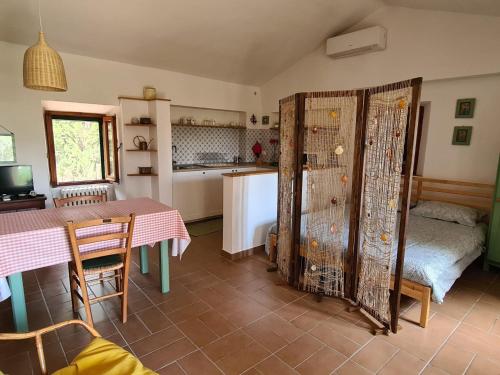 Una cocina y un comedor con una mesa y una habitación con una cama. en Il Casale Delle Farfalle, en Sirolo
