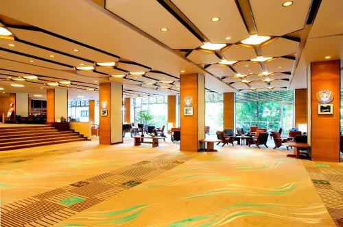 un vestíbulo con mesas y sillas en un edificio en Ooedo Onsen Monogatari Hotel New Shiobara en Nasushiobara