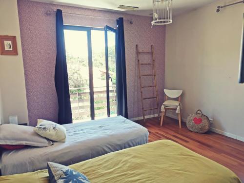 Cette chambre comprend deux lits et une fenêtre avec une échelle. dans l'établissement L' Arbouseraie, à Saint-Raphaël
