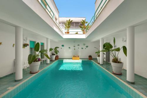 una piscina cubierta con macetas en un edificio en Villa Zio Tore by BarbarHouse, en Torre Suda