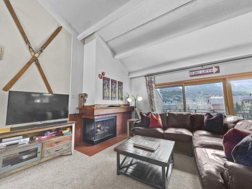 a living room with a couch and a tv and a fireplace at Pg309 Peregrine Condo in Copper Mountain