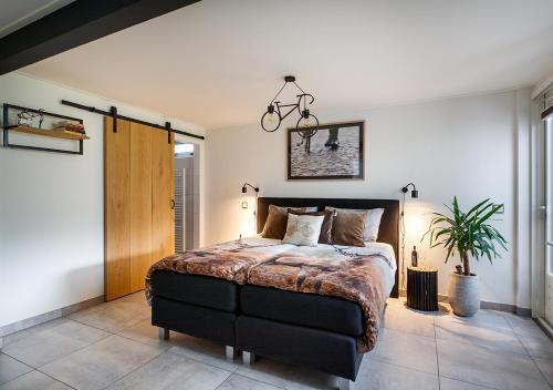 sypialnia z łóżkiem i doniczką w obiekcie Velo-Droom w mieście Otterlo
