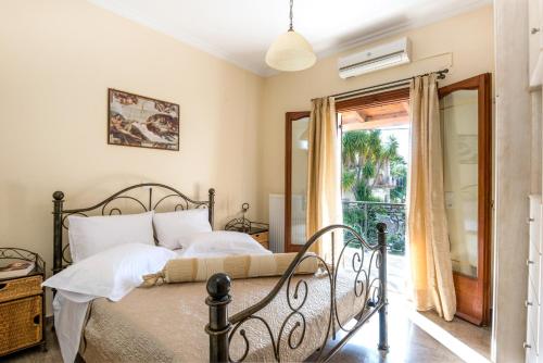 een slaapkamer met een bed en een glazen schuifdeur bij Virginia - Home in Helmata Argostoli in Argostoli