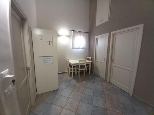 a small room with a table and a white refrigerator at Le Plejadi in Castellammare del Golfo