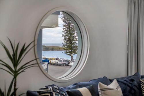 a circular mirror in a living room with a couch at La Ronde Three - Unit 3 - Oceanstays in Yamba